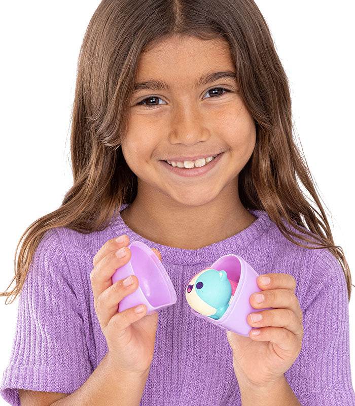 Girl holding Aphmau Mystery MeeMeows Squishy Figure in a purple container.