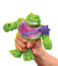 Load image into Gallery viewer, Goo Jit Zu Stretch Strikers Rock Jaw toy being stretched in a hand, showcasing its gooey filling and flexible design.