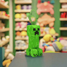 Load image into Gallery viewer, Minecraft 5 Inch Creeper bag hanger plush with pixelated detailing on display in a store setting.