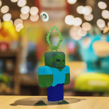 Load image into Gallery viewer, Minecraft 5 Inch Zombie Bag Hanger Plush with pixelated design on blurred background.
