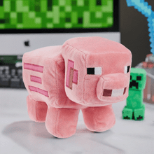 Load image into Gallery viewer, Minecraft 8&quot; Pig Plush with pixelated detailing on a desk setup.
