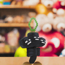 Load image into Gallery viewer, Minecraft 5 Inch Wither Bag Hanger Plush with pixelated design and clip, displayed in store.
