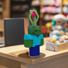 Load image into Gallery viewer, Minecraft 5 Inch Zombie Bag Hanger Plush on display with clip, featuring authentic pixelated design.

