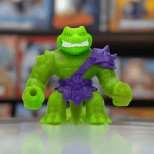 Load image into Gallery viewer, Heroes of Goo Jit Zu Stretch Strikers Rock Jaw toy figure with green stretchy body and purple armor.
