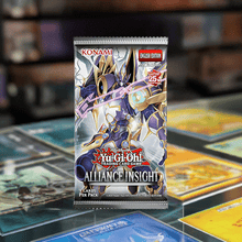 Load image into Gallery viewer, Yu-Gi-Oh Alliance Insight Booster Pack featuring vibrant packaging on a display table surrounded by trading cards.
